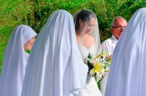 Novia sonríe con velo en su boda